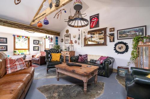 a living room with leather furniture and a table at The Hideaway Muff in Muff