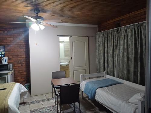 a bedroom with two beds and a ceiling fan at Willow Guest house in Vereeniging