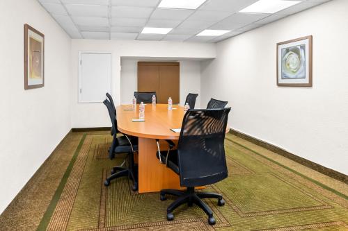 a conference room with a wooden table and chairs at Suburban Studios Slidell I-10 in Slidell