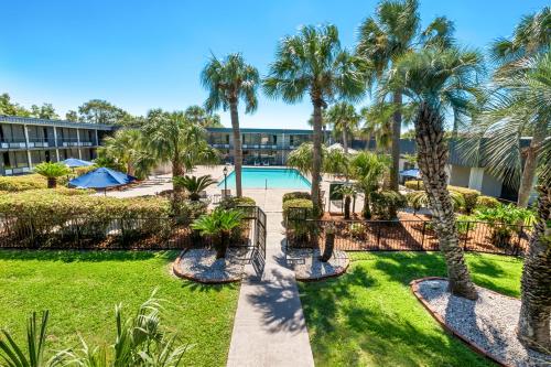 a view of a resort with palm trees and a pool at Suburban Studios Slidell I-10 in Slidell