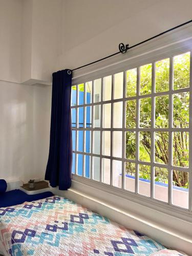 a bedroom with a large window in front of a bed at La Puerta del Sol in Coco