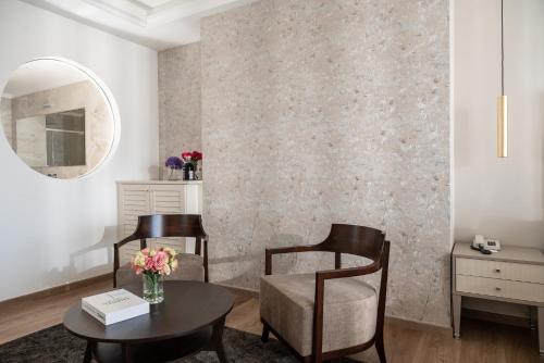 a living room with a table and two chairs and a mirror at Grand Hotel Gallia in Milano Marittima