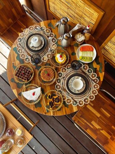 a wooden table with plates of food on it at Alma Charme Atins in Atins