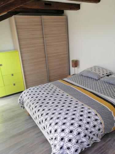 - une chambre avec un grand lit et un placard en bois dans l'établissement Vieille grange rénovée, à Saint-Martial-Entraygues