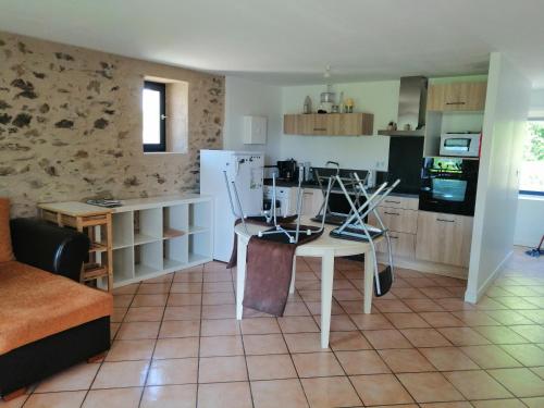 une cuisine avec une table et des chaises dans une pièce dans l'établissement Vieille grange rénovée, à Saint-Martial-Entraygues