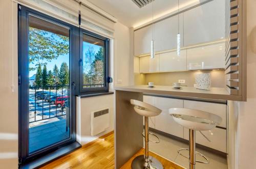 a kitchen with a counter and stools in front of a window at Titova vila Zlatibor Nika in Palisad