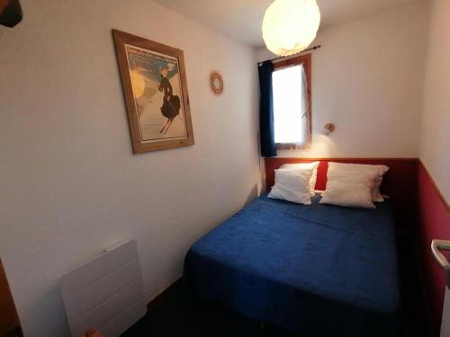 - une petite chambre avec un lit bleu et une fenêtre dans l'établissement Résidence Le Chanteloup - 2 Pièces pour 4 Personnes 104, à Aime La Plagne