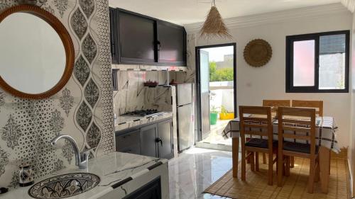 a kitchen with a sink and a table with chairs at Appartement berj in Oualidia