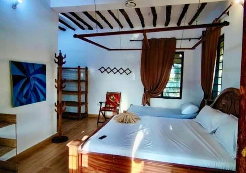 a bedroom with a large bed in a room at The Tropinest bungalow in Nungwi