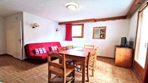 un salon avec une table et un canapé rouge dans l'établissement Résidence Parc Aux Etoiles - GEB12 - APPARTEMENT 2 CHAMBRES ET TERRASSE MAE-7331, à Narreyroux