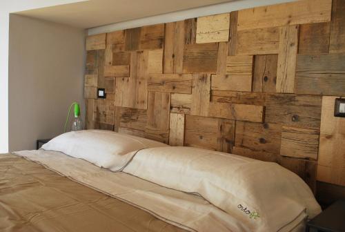 a bedroom with a wall made out of wood at OrtoPì Country Canapa House in Porto Recanati