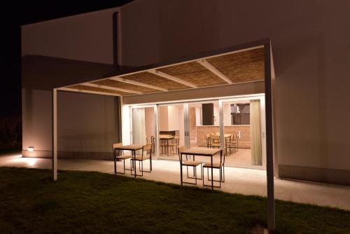 a patio with a table and chairs at night at OrtoPì Country Canapa House in Porto Recanati