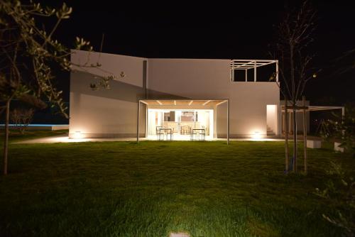 a house at night with a lawn in front of it at OrtoPì Country Canapa House in Porto Recanati