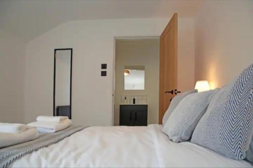 a bedroom with a white bed with a large mirror at Modern Luxury 4 Bed House in Heart of Macclesfield in Macclesfield