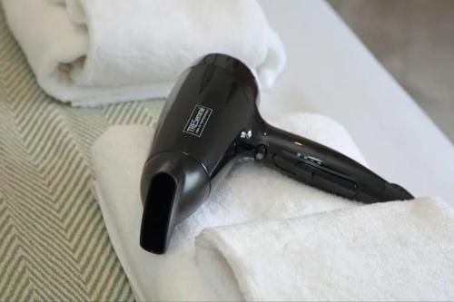 a hair dryer sitting on top of a bed at Modern Luxury 4 Bed House in Heart of Macclesfield in Macclesfield