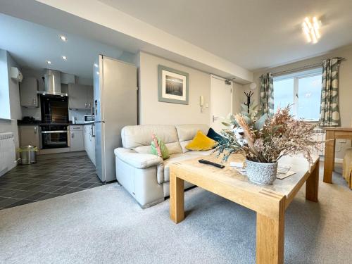 a living room with a couch and a table at The Warehouse Apartments, 1 - Bed, Sleeps 2, Ulverston - UK in Ulverston