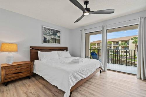 a bedroom with a bed and a ceiling fan at Beachfront resort Heated Pool 3King beds 85in TV BBQ in Saint Augustine Beach