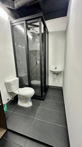 a bathroom with a toilet and a shower at Hotel Capsulas Quito in Quito