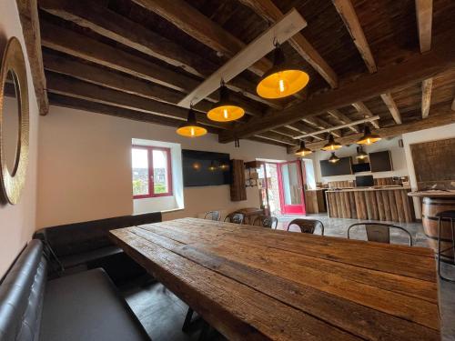 une grande table en bois dans une pièce avec des chaises dans l'établissement LE RELAIS DES CALECHES - La Balinaise, à Broué