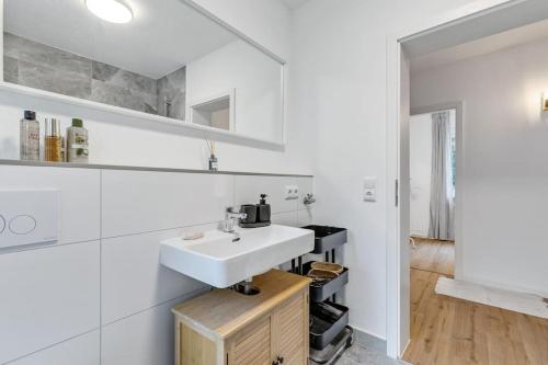 a bathroom with a sink and a white wall at Cityperle - im Herzen Augsburgs in Augsburg