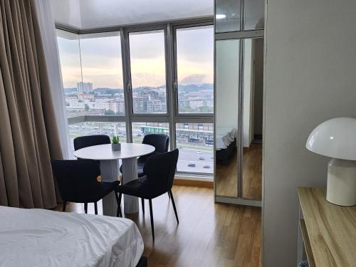 a room with a table and chairs and a large window at One South 3bedroom, MRT to TRX in Seri Kembangan