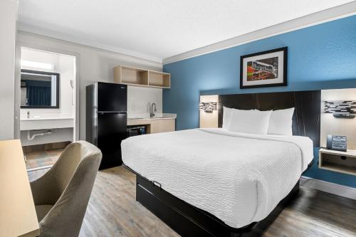 a hotel room with a bed and a chair at Suburban Studios Slidell I-10 in Slidell