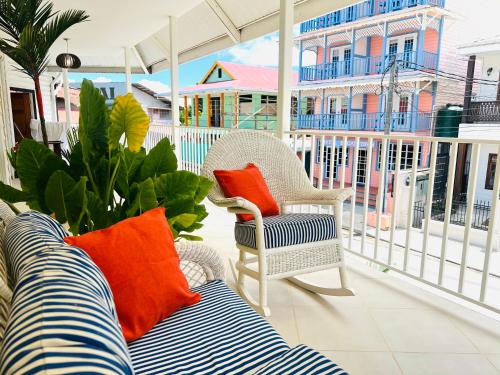 a patio with a couch and a chair on a balcony at Hotelito del Mar - Main Street in Bocas del Toro