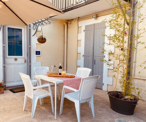une table blanche et des chaises sur une terrasse dans l'établissement Gites Rue Du Chateau, à Ruffec