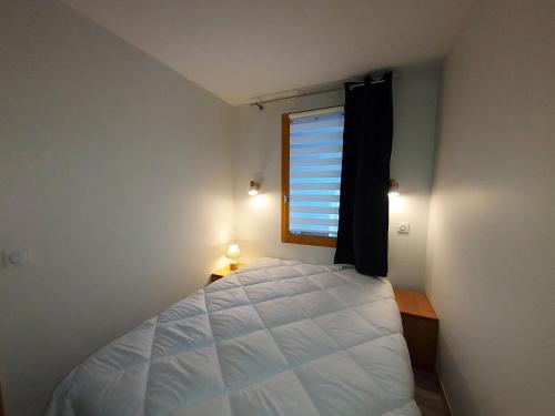 une chambre avec un lit blanc et une fenêtre dans l'établissement Résidence Mucillon G - MUCILLON 5 MAE-3761, à Valmorel