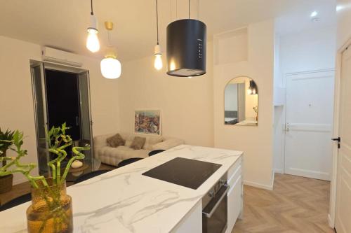 une cuisine avec un comptoir blanc et un salon dans l'établissement Luxueux T3 aux portes de Monaco, à Beausoleil