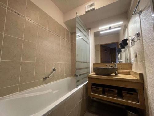 une salle de bain avec un lavabo, un miroir et une baignoire dans l'établissement Résidence Prince Des Ecrins - Appartement avec terrasse refait à neuf avec vue panoramique montagne MAE-5541, à Vénosc