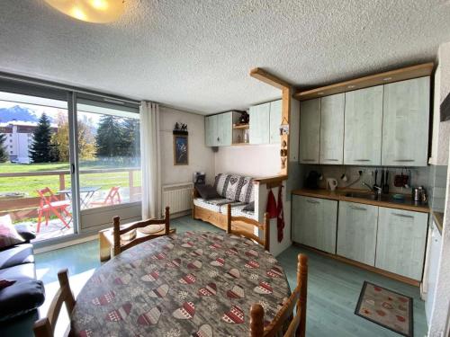 - un salon avec une table et une cuisine avec vue dans l'établissement Résidence Cote Brune 5 - Studio pour 5 Personnes 551, à Vénosc
