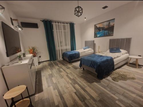 a bedroom with two beds and a table and chairs at Apartament Zacisze 4 in Przemyśl