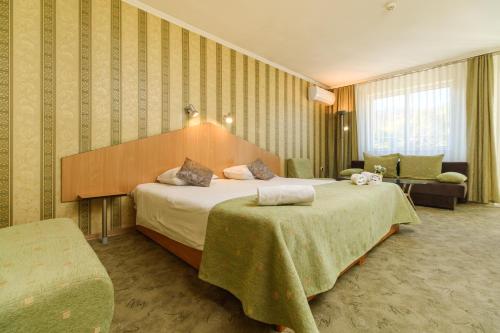 a hotel room with a large bed and a couch at Noviz Hotel in Plovdiv