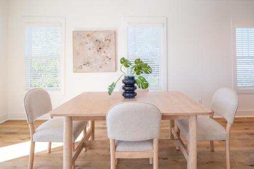 a dining room table with chairs and a plant on it at Luxury Pet Friendly New Build - Go with the Flo 2 in Carolina Beach