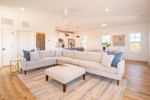 a living room with a white couch and blue pillows at Luxury New Build with Oceanview - Grow With The Flow in Carolina Beach