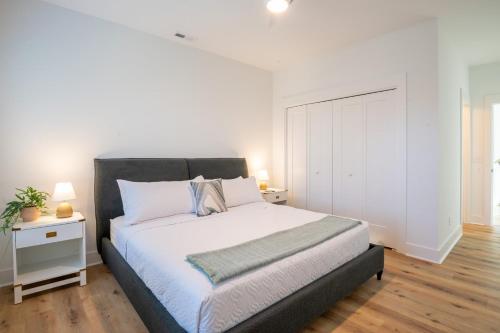 a bedroom with a large bed and a white wall at Luxury Pet Friendly New Build - Go with the Flo 2 in Carolina Beach
