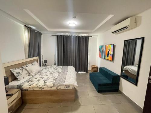 阿克拉Luxury Labone Edge 2-bedroom apartment in Accra - FiveHills homes的一间卧室，有一张床和一把蓝色椅子