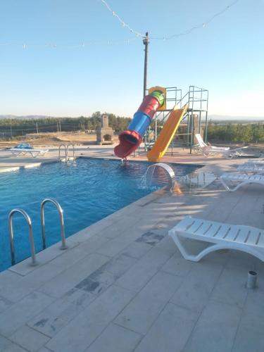 a slide in the middle of a swimming pool at KANYONUM Hotel in Ulubey