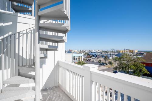 a balcony with white stairs and a view of the city at Luxury New Build with Oceanview - Grow With The Flow in Carolina Beach
