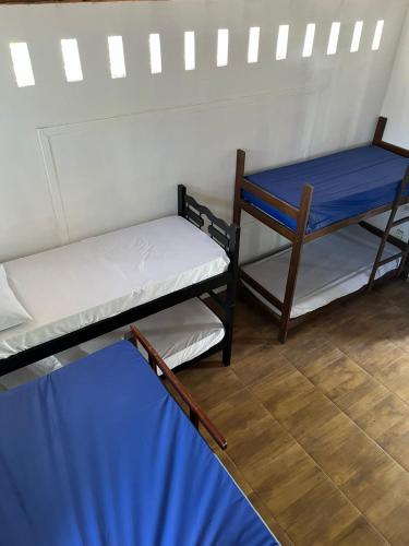 a room with two bunk beds and a blue sheet at Destino Hospeda in Pipa