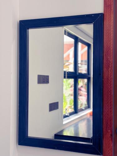 a mirror on a wall with a window at Mathiveri Thundi Inn in Mathiveri