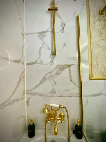 a sink with a gold faucet and a cross on a wall at El Balcón de Fuenteheridos in Fuenteheridos