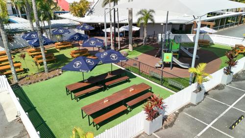 an overhead view of a park with benches and umbrellas at Currimundi Hotel in Caloundra