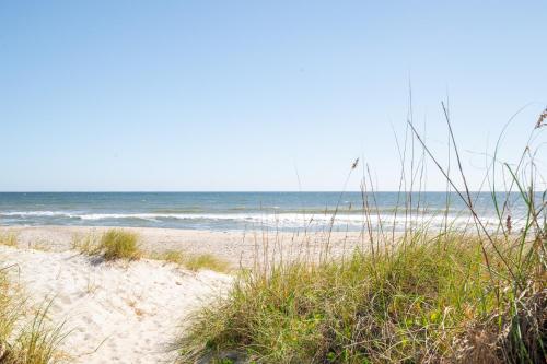 a sandy beach with the ocean in the background at Luxury New Build with Oceanview - Grow With The Flow in Carolina Beach