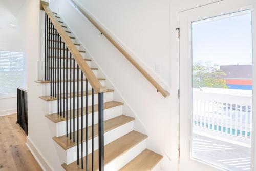 a staircase in a house with a glass door at Luxury New Build with Oceanview - Go with the Flo 1 in Carolina Beach