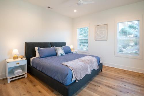 a bedroom with a large bed with blue pillows at Luxury New Build with Oceanview - Go with the Flo 1 in Carolina Beach