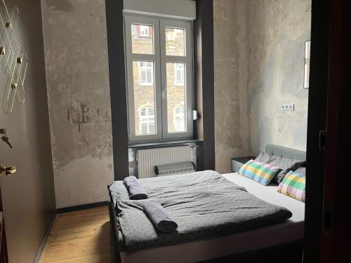 Un dormitorio pequeño con una cama con ventana. en Vis-a-vis Apartments, en Traben-Trarbach