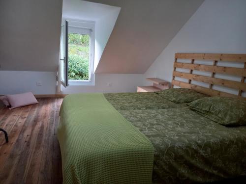 une chambre avec un lit vert et une fenêtre dans l'établissement L'Hermitage, à Auxi-le-Château