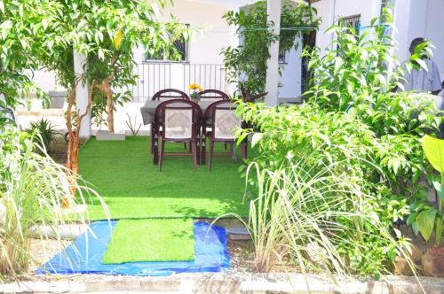 a patio with a table and chairs in a garden at Résidence Merveilles D20 in Kribi